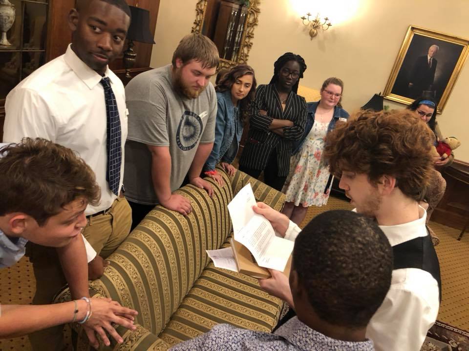 students circle around a couch